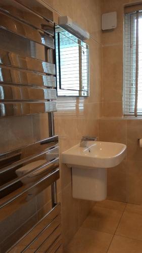 baño con lavabo blanco y ventana en Allt Nan Ros Apartments fort william, en Onich