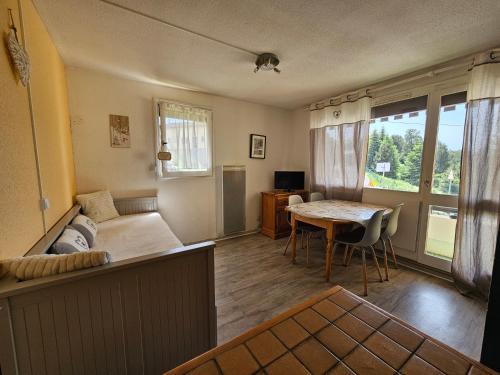 - un salon avec un lit, une table et une table dans l'établissement Studio Mouflon RDC balcon plein SUD garage FONT-ROMEU, à Font-Romeu-Odeillo-Via