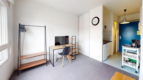 Cette chambre comprend un bureau et une horloge murale. dans l'établissement Bastion - Studio center with elevator, au Havre