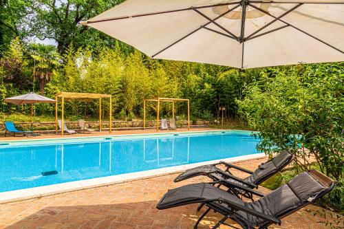 a pair of chairs and an umbrella next to a swimming pool at Radius Horse Ranch B&B in Massa Martana