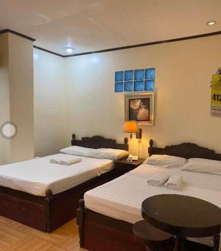 a room with two beds and a table in it at Sugarland Suites in Ormoc