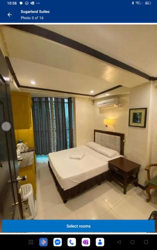 a bedroom with a bed and a table in it at Sugarland Suites in Ormoc
