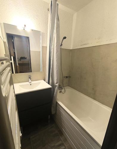 une salle de bain avec un lavabo et une baignoire dans l'établissement Serre Chevalier Appt 1er étage 4p Aiglon sud, à La Salle Les Alpes