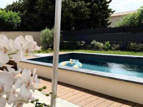une piscine au milieu d'une arrière-cour dans l'établissement Maison 120m, jardin, parking, piscine, à Sainte-Cécile-les-Vignes