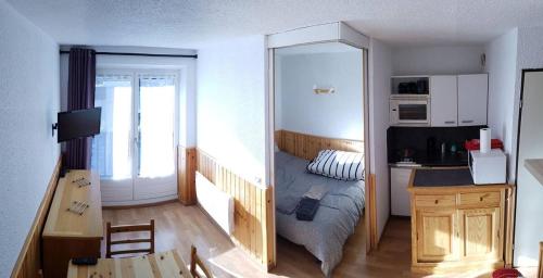 une petite chambre avec un lit et un miroir dans l'établissement Serre Chevalier Appt 1er étage 4p Aiglon sud, à La Salle Les Alpes