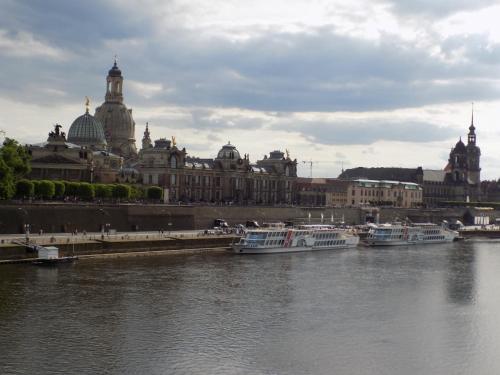 eine Gruppe von Booten in einem Fluss vor einem Gebäude in der Unterkunft Pension Kellei 71 in Dresden