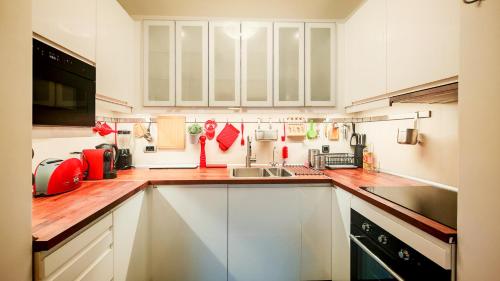 uma cozinha com armários brancos e uma pia em FilinHome Dusana Suite 2 em Novi Sad