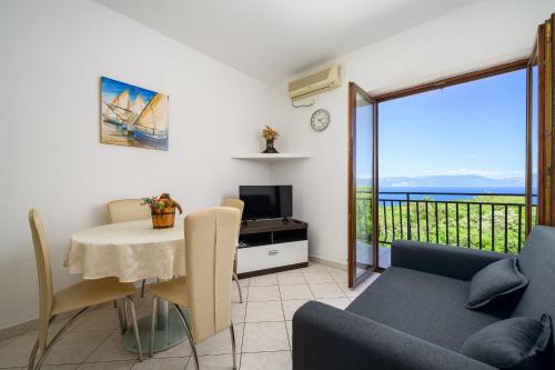 a living room with a table and a couch and a television at Serene Summer Oasis - Pool, Jacuzzi, Sauna, Sea View - Lara in Drenje
