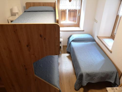a small bedroom with two beds and a window at La Terrazzetta Val Comelico in Santo Stefano di Cadore