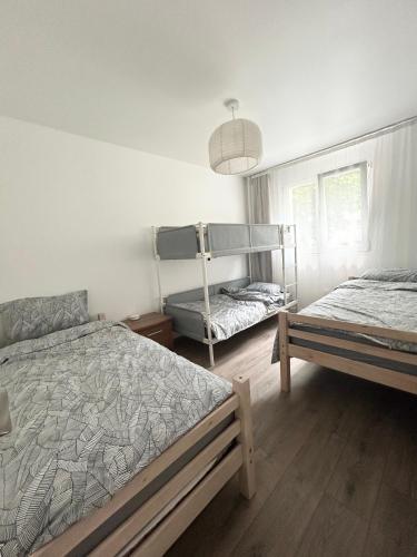 une chambre avec deux lits et une lampe dans l'établissement appart idéal en famille parking privé, à Drancy