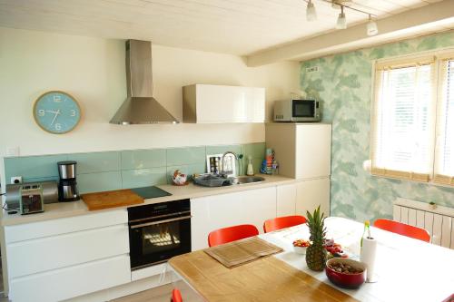 une cuisine avec une table et une horloge au mur dans l'établissement Maison de vacances à Quend-plage, à Quend-Plage