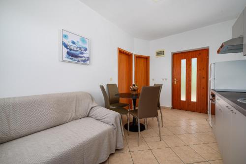 a living room with a couch and a table at Serene Summer Oasis - Pool, Jacuzzi, Sauna, Sea View - Lara in Drenje