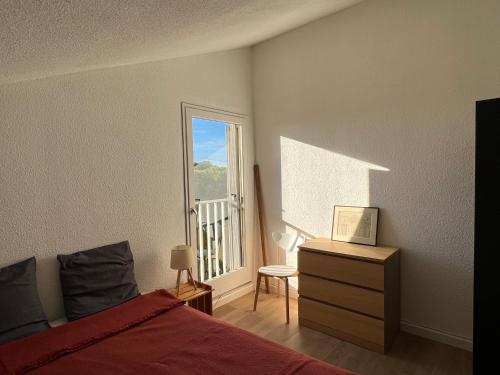 une chambre avec un lit et une fenêtre avec un balcon dans l'établissement studio à 400m de la plage de la Corniche, à Sète