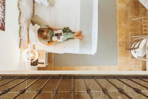 a woman laying on a bed in a room at La Bastide des Salins in Saint-Tropez