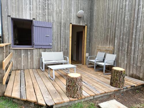 Saint-FrontにあるGîte La Draï L'âme du trappeur au pied d'un volcanの木製デッキ(椅子2脚、テーブル1台付)