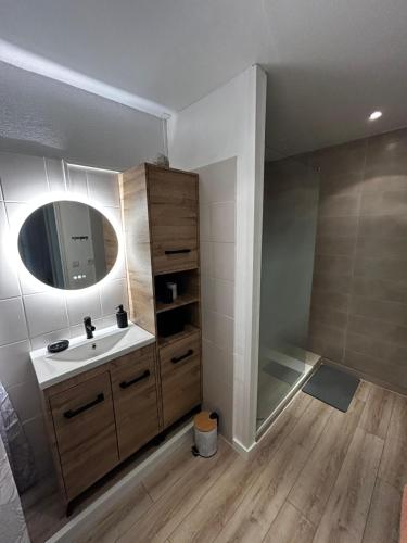 une salle de bain avec un lavabo et un miroir dans l'établissement Appartement cosy centre Uzès, parking gratuit, piscine, à Uzès