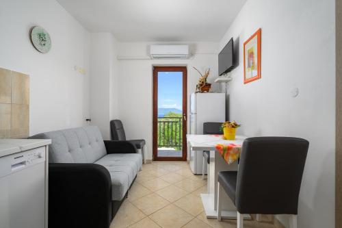 a living room with a couch and a table at Serene Summer Oasis - Pool, Jacuzzi, Sauna, Sea View - Lara in Drenje