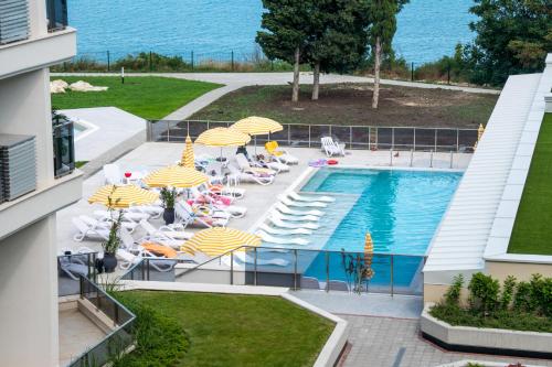 a swimming pool with lounge chairs and umbrellas at Skyline 11B Apartment - Sea View,Pools & SPA in Varna City