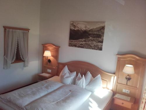 a bedroom with a bed with white sheets and pillows at Tirol Appartement Haus Zillertal in Zell am Ziller