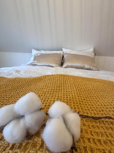 a bed with three white cotton balls on it at Rezidenca Vista Lux in Ptuj