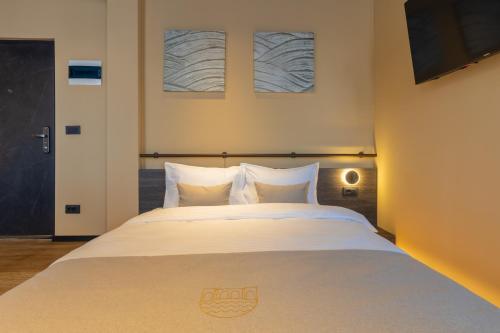 a bedroom with a large bed with white sheets at Agara Stays Prizren in Prizren