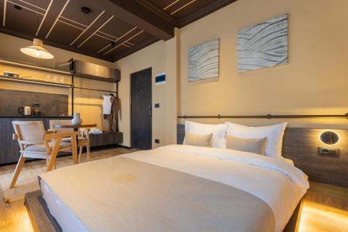 a bedroom with a large white bed and a table at Agara Stays Prizren in Prizren