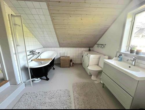 a bathroom with a sink and a tub and a toilet at Roslagen sjötomt ,gårdshus på större gård in Grisslehamn