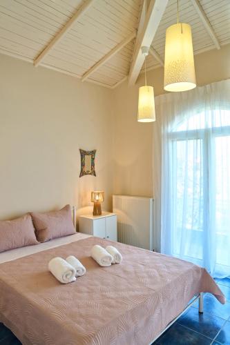a bedroom with a large bed with two towels on it at Grand Villa Maronia in Platanitis Rodopis
