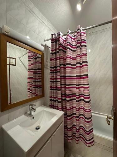 a bathroom with a sink and a shower curtain at Alvor Riverview in Alvor