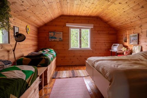 a room with two beds in a log cabin at Scandinavian summer cottage in Asikkala in Asikkala