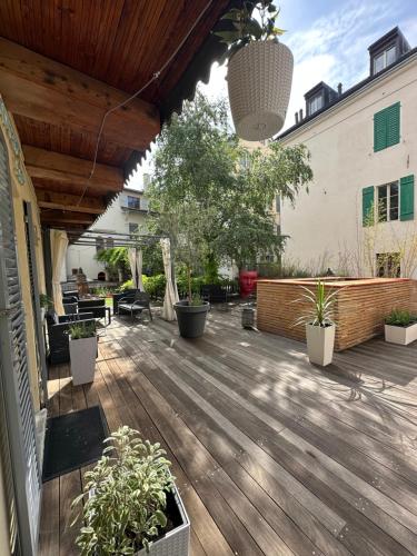 a patio with potted plants and a wooden deck at Terrasses de Valère in Sion