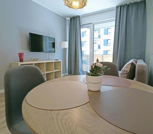 a living room with a table and chairs and a tv at Gold Key komfortowy apartament z balkonem, klimatyzacja i parkingiem in Pruszków