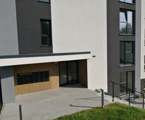 a large white building with a brown door at Apartament Zielone Wzgórze 3 in Jelenia Góra