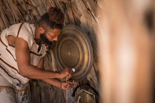 a man is working on a artifact in a wall at Ethno Belek in Belek