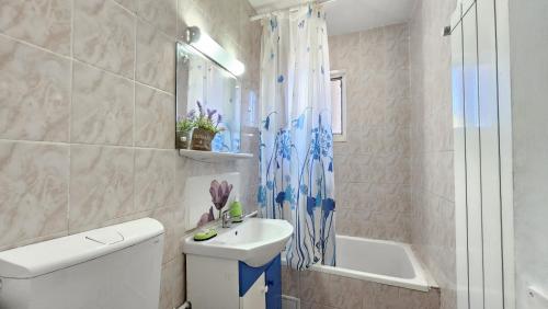a bathroom with a sink and a toilet and a tub at To the Nerversea beach! in Constanţa