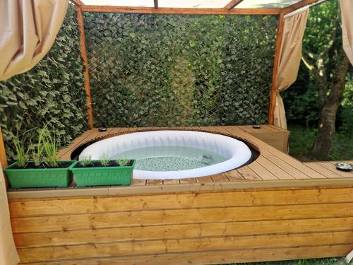 a hot tub with two potted plants on a wooden deck at Domek Pattie in Giżycko