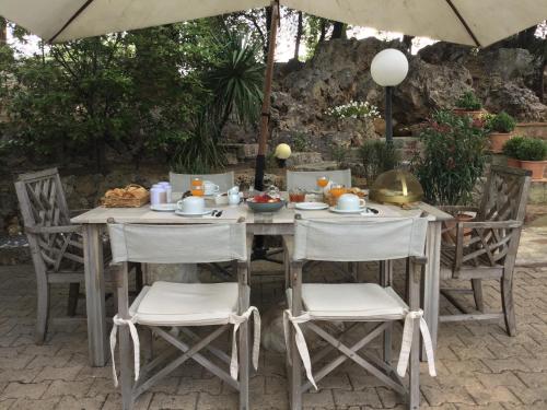 een buitentafel met stoelen en een parasol bij Villa San Marco chambre d hôtes in Lorgues