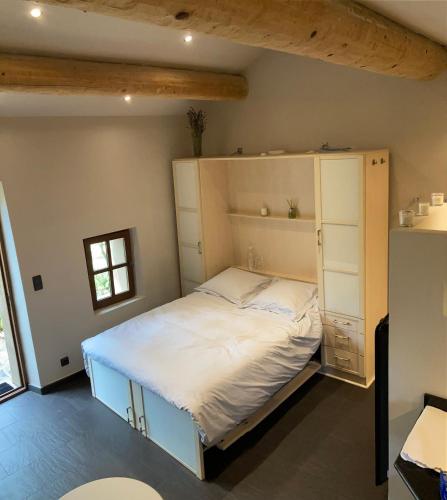 - une chambre avec un grand lit et des étagères dans l'établissement Villa San Marco chambre d hôtes, à Lorgues