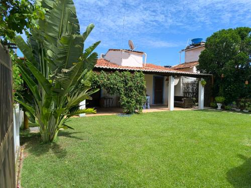 a house with a yard with green grass at CASA MAR DOCE LAR GOSTOSO - A 150M DA PRAIA in São Miguel do Gostoso