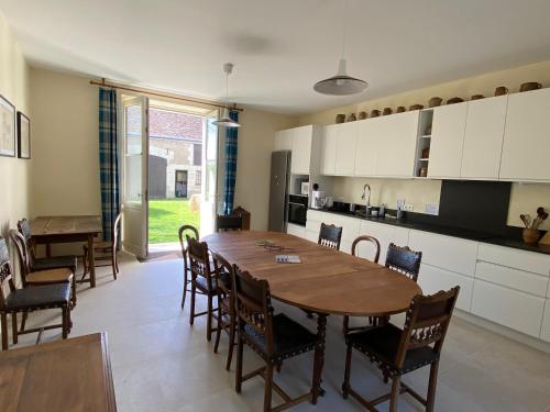 une cuisine et une salle à manger avec une table et des chaises en bois dans l'établissement La maison de Théophile, à Sepmes