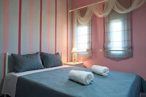 a bedroom with a blue bed with two towels on it at Grand Villa Maronia in Platanitis Rodopis
