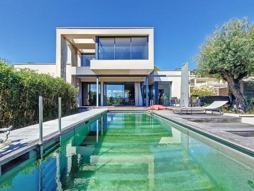 une maison avec une piscine devant une maison dans l'établissement Villa Architecte Détente Piscine Privée Cinéma, à Sète