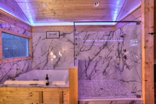 a bathroom with a tub and a marble wall at Ultimate Couples Retreat w Fenced Yard for Pet in Cleveland