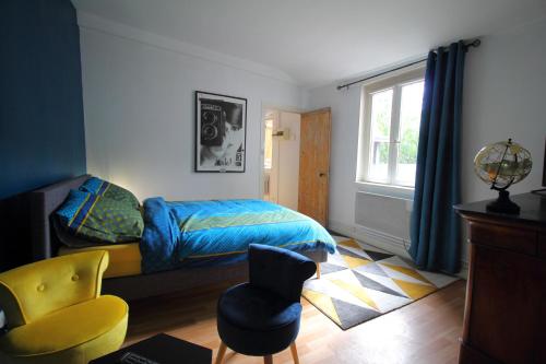 une chambre avec un lit, une chaise et une fenêtre dans l'établissement T1 charme, calme, Fibre, Proche bords de Loire, à Orléans