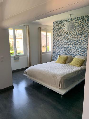 une chambre avec un grand lit avec un mur bleu dans l'établissement Maison avec piscine, à Carpentras