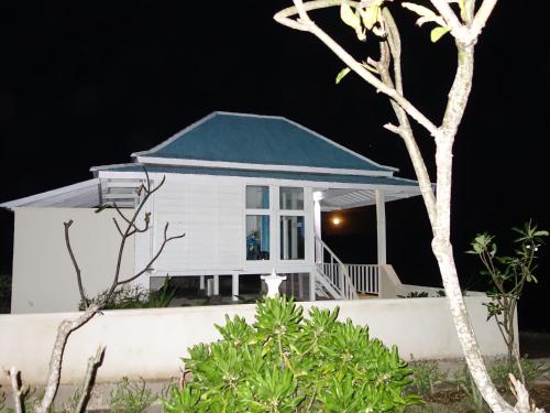 a white house with a blue roof at night at Cliff Park Lembongan in Nusa Lembongan