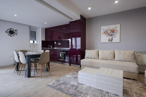 a living room and kitchen with a couch and a table at Apartmani Lepojevic in Prokuplje