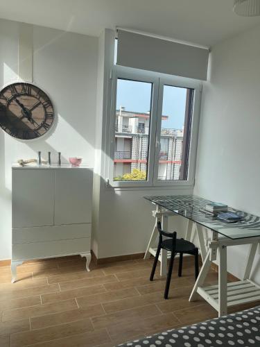a room with a desk and a clock and a window at Le maree in Grado