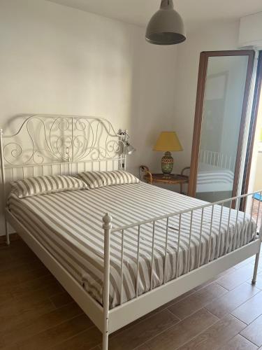 a white bed in a bedroom with a mirror at Le maree in Grado