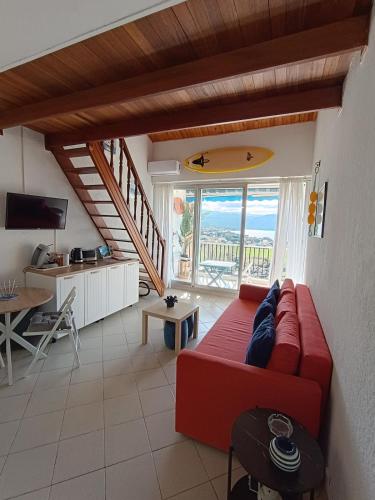 un salon avec un canapé rouge et une table dans l'établissement embarquement au marine du soleil, à Patrimonio